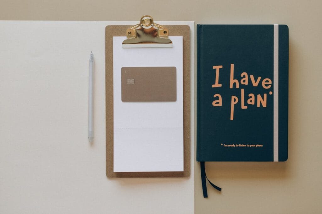 pexels-photo-8062358 A minimalist office setup featuring a planner, clipboard, card, and pen, perfect for planning and organization.
